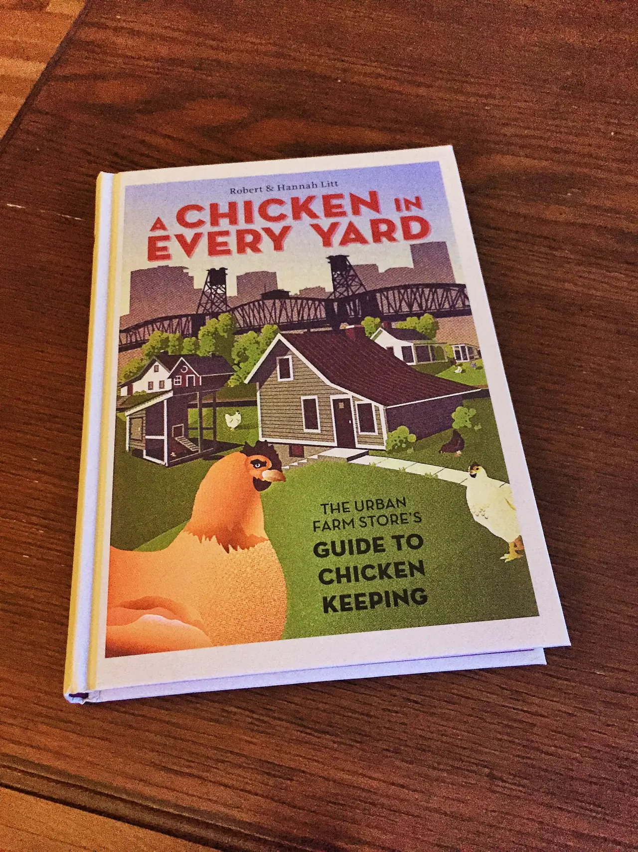 A Chicken in Every Yard by Robert and Hannah Litt lying on a wooden table