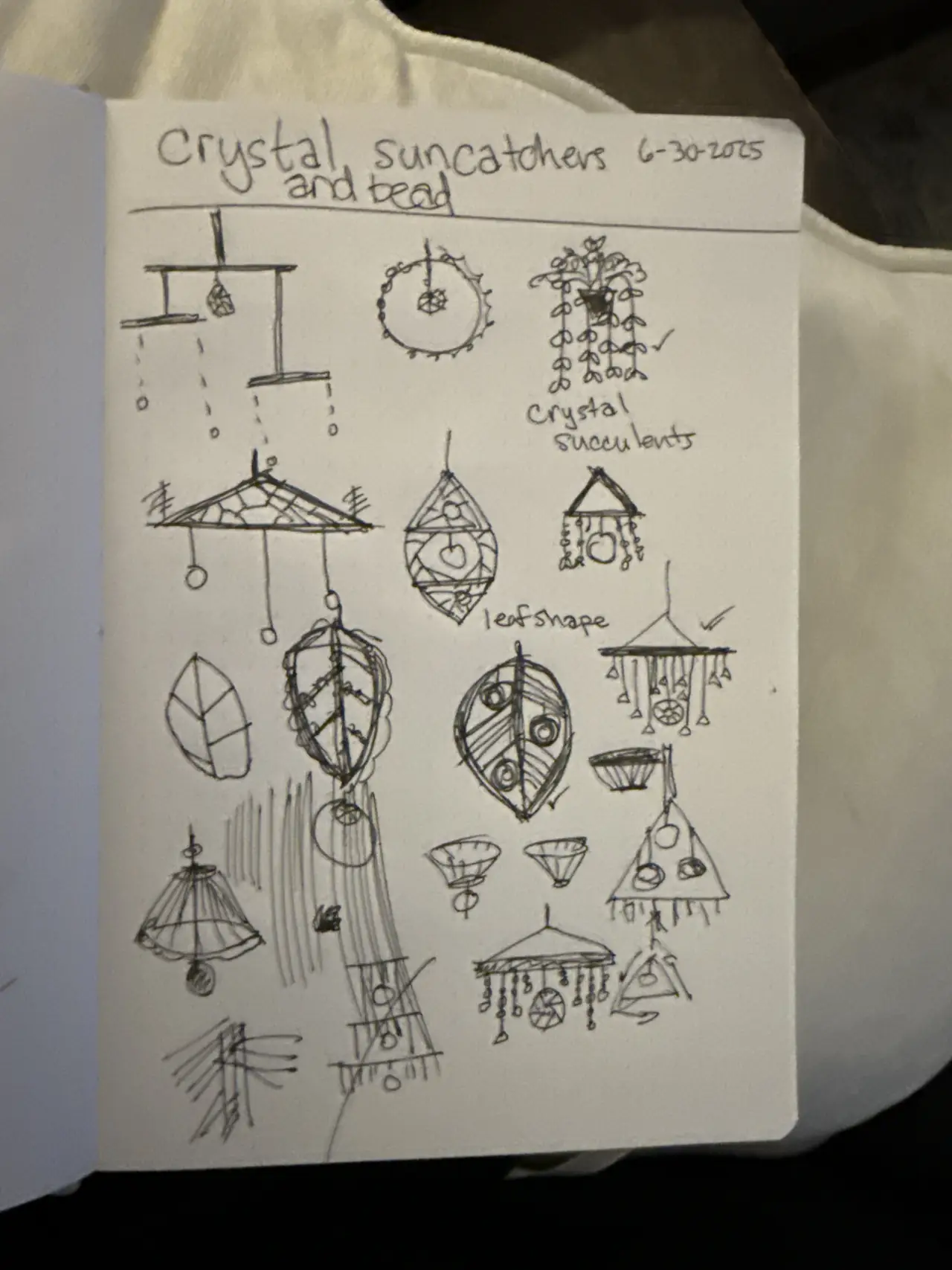 A sketchbook page of pencil designs for crystal suncatchers