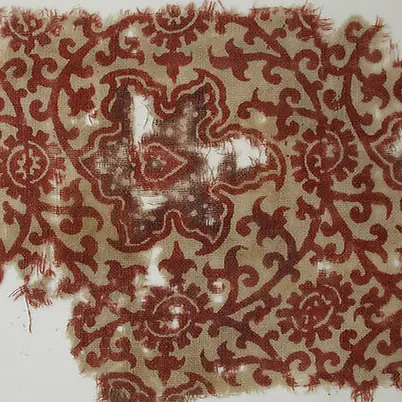 Red scrolling leaves on a historic block-printed cotton fragment
